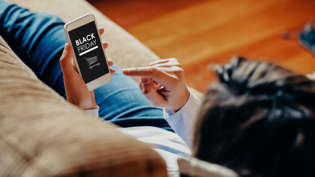 Woman shopping on couch looking at Black Friday deals