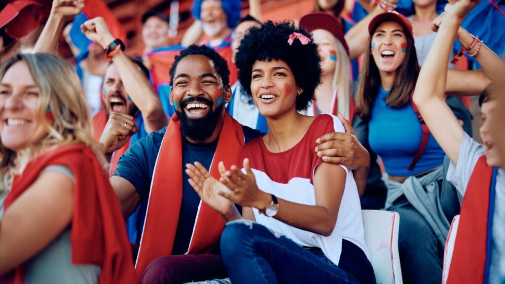 A diverse group of enthusiastic fans enjoying a sports and entertainment championship at a stadium.